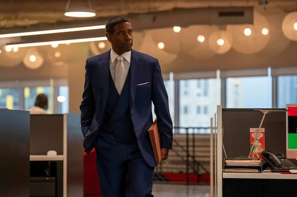 Denzel Washington in a blue suit walks in an office in Highest 2 Lowest.