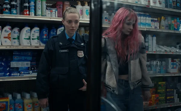 A policewoman and a woman with pink hair stand in a store in Long Bright River.
