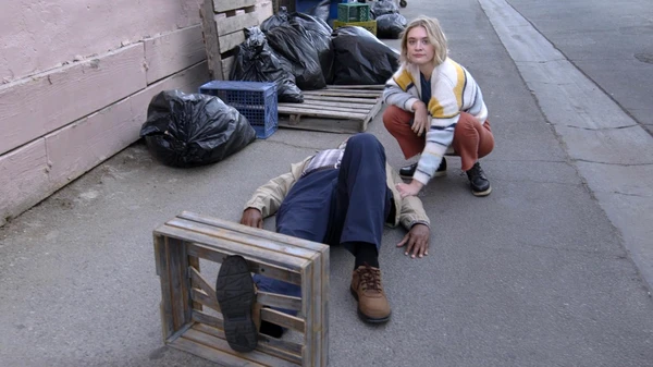 A reporter in The Paper checks on a person lying on a street.
