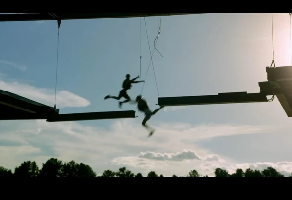 Contestants on The Snake engage in an intense challenge, silhouetted against the sky.