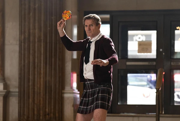 A man in a kilt holds a lollipop in a scene from The Naked Gun.